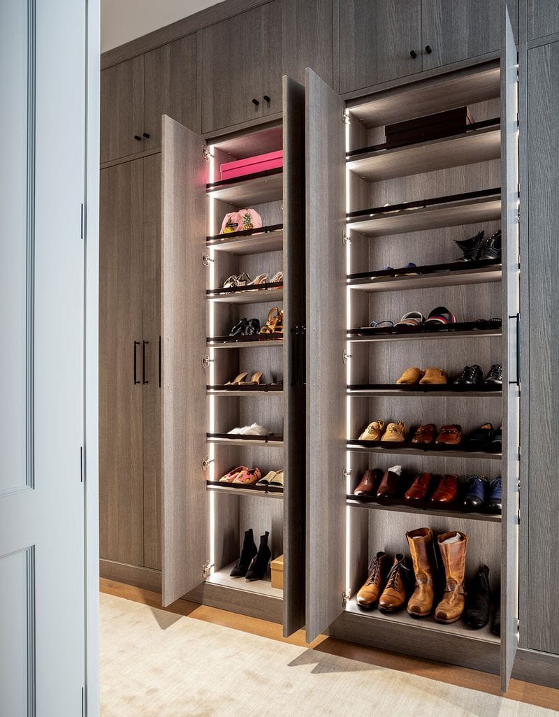 Shoe storage in Ryan Serhant's walk in closet in light wood grain finish by California Closets