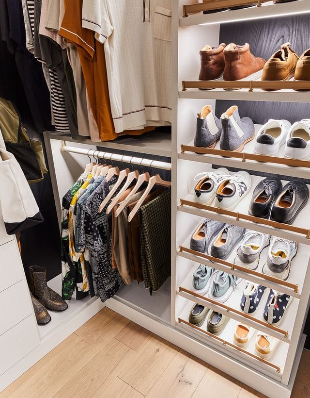 Titled shoe storage organization in Bobby Berk’s walk in closet designed by California Closets